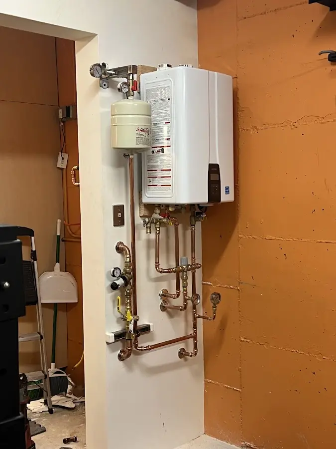Plumbing technician inspecting water heater connections in Winston